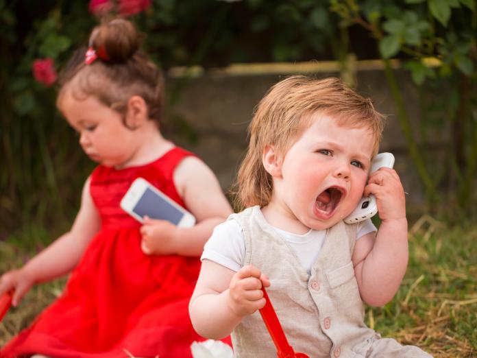 To piger leger med telefoner